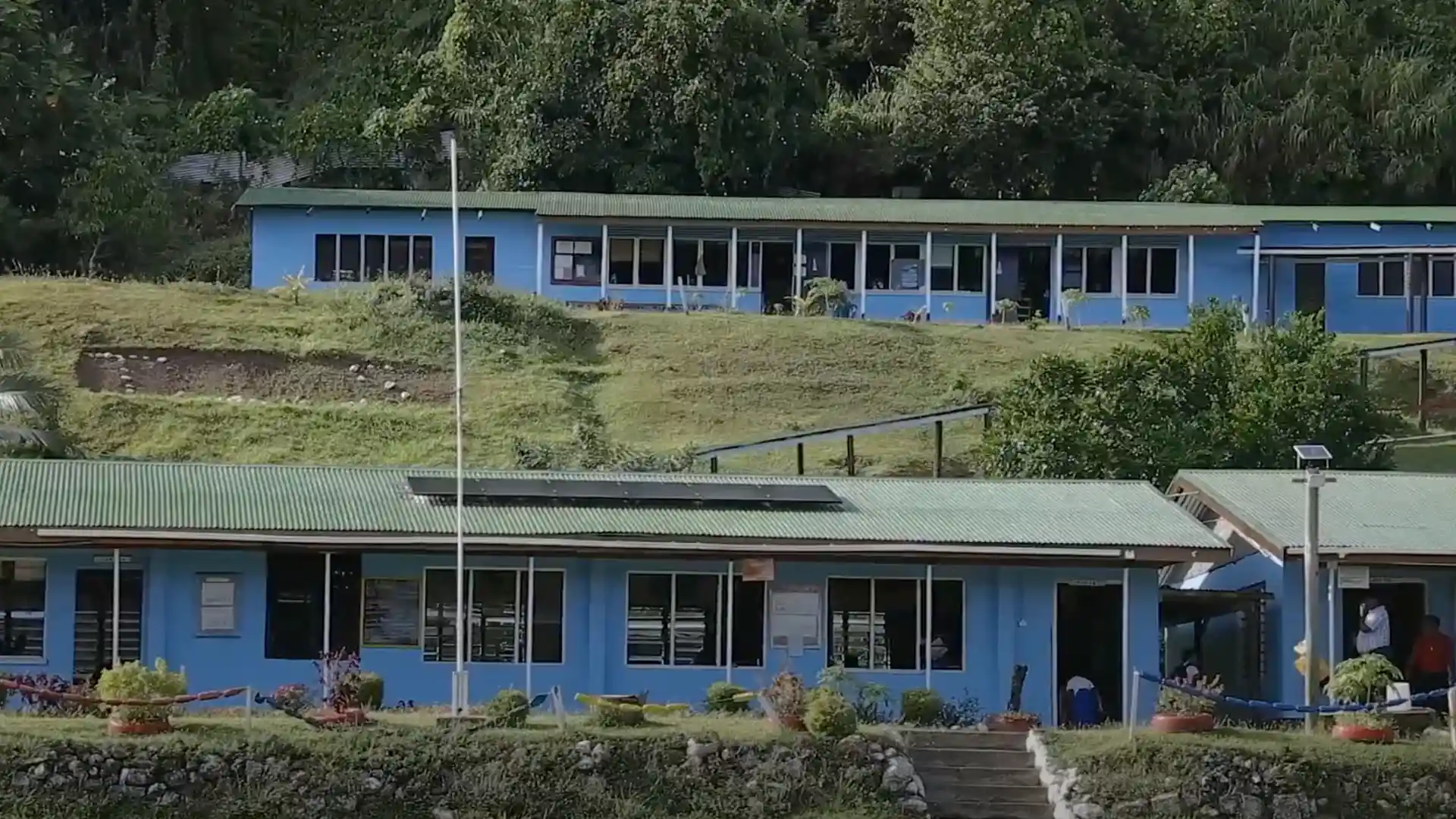 Remote Fijian school with rooftop solar panels providing electricity for classrooms