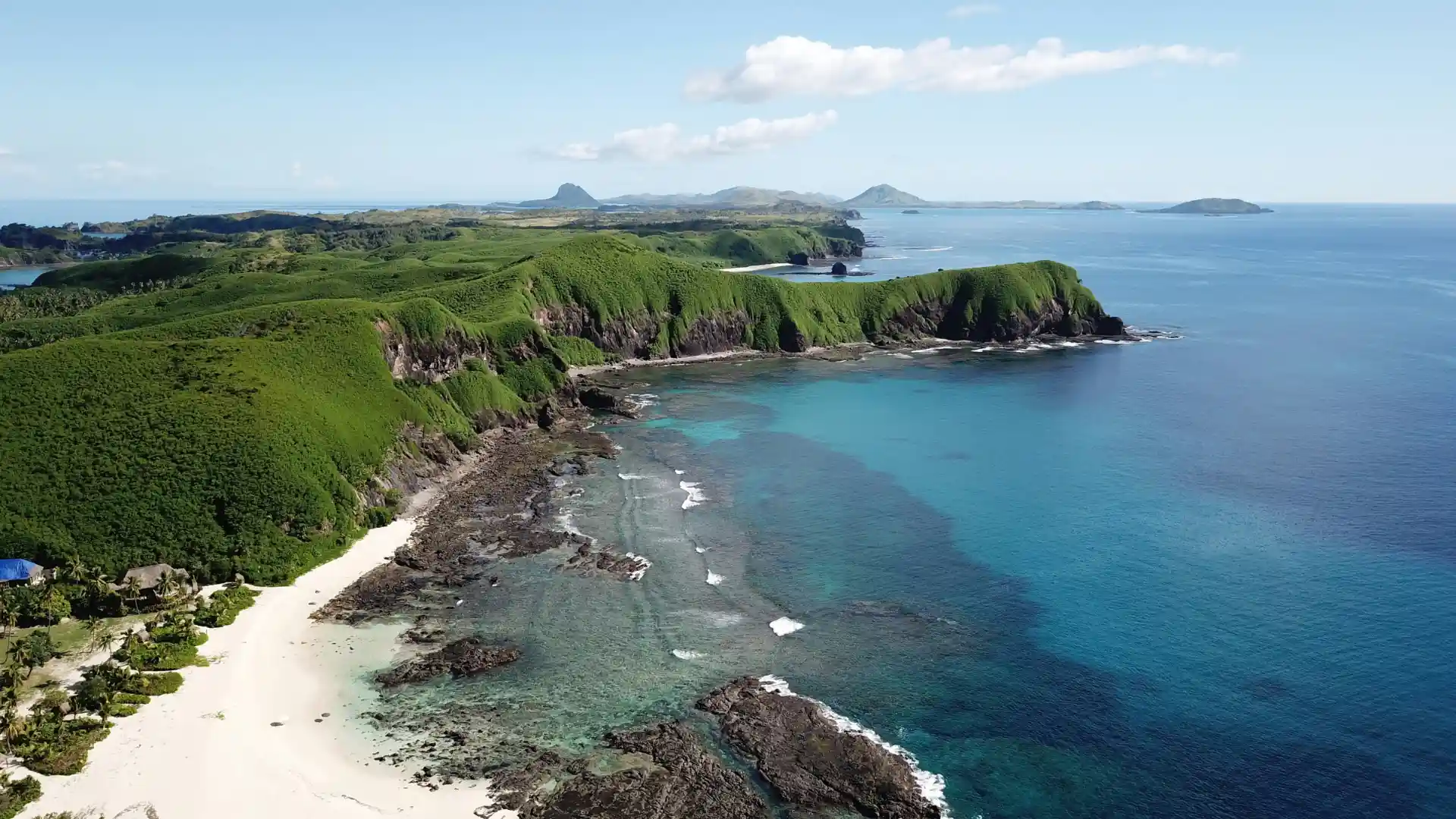 Aerial view of a tropical Fijian island surrounded by ocean waves