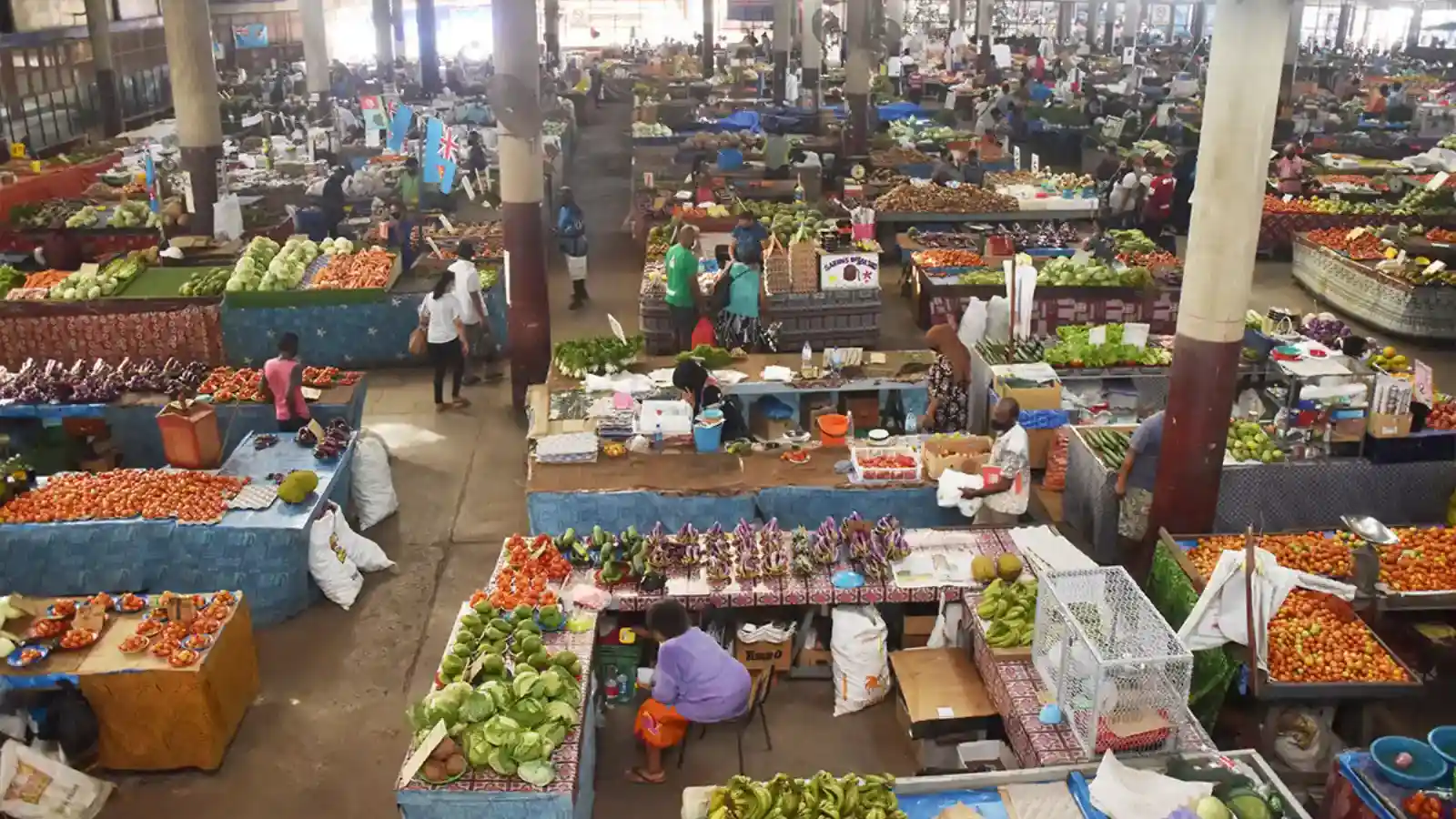 Busy Lautoka Market with vendors selling fresh tropical fruits, vegetables and spices to local shoppers in Fiji's sugar capital