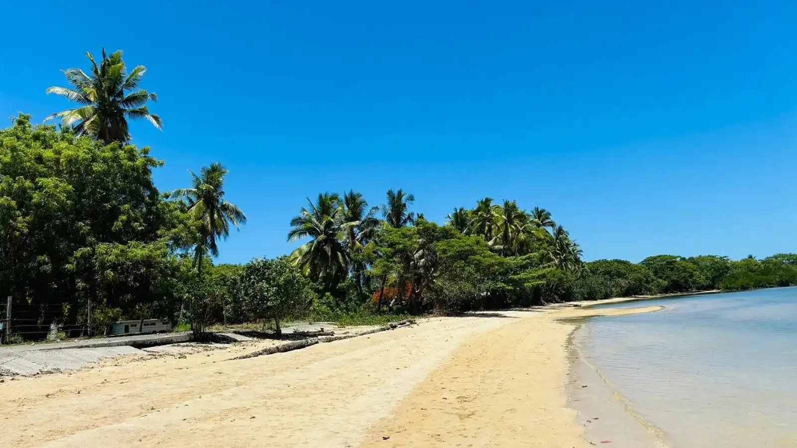 Golden sands and calm waters at Saweni Beach near Lautoka, Fiji, with palm trees and sunset over Mamanuca Islands