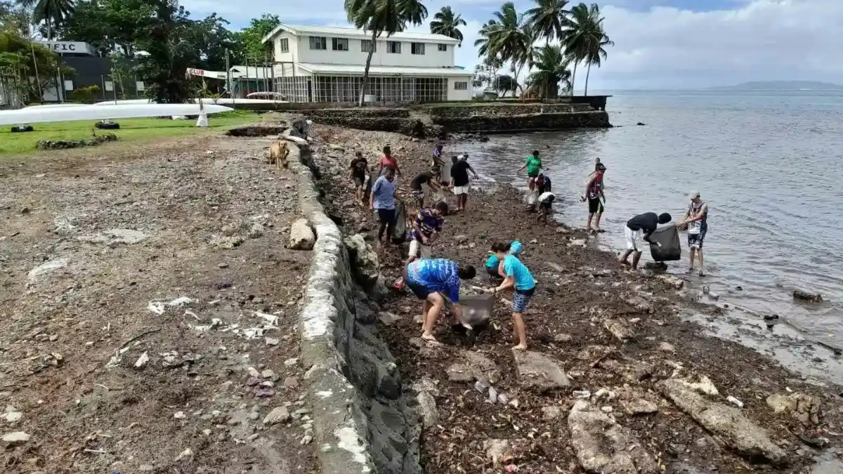 Volunteers collecting litter along a beach shoreline