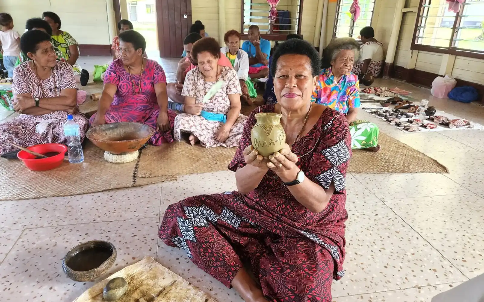 Fijian woman shaping clay pottery by hand in Nakabuta Village