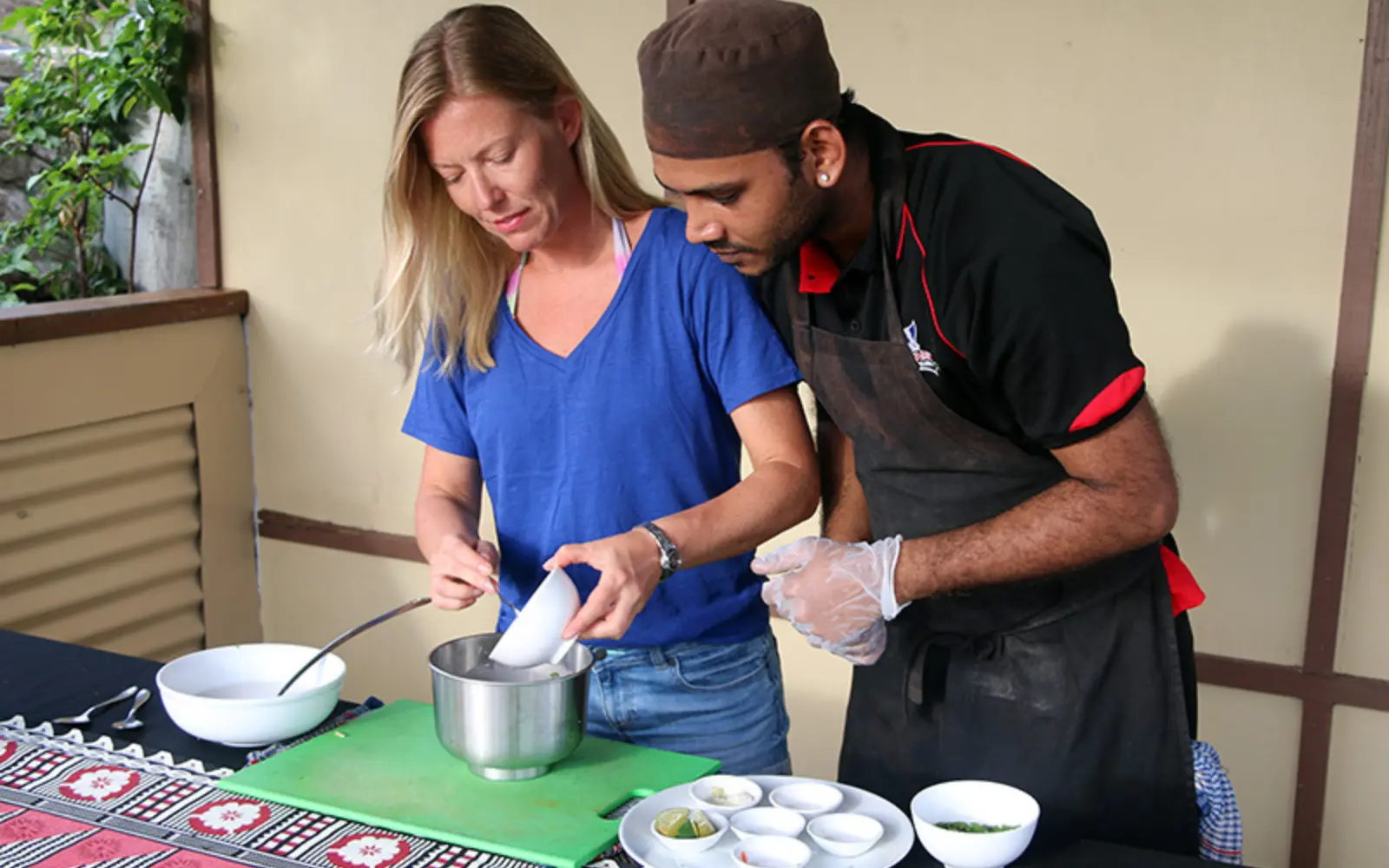 Guests preparing kokoda in a traditional Fijian kitchen