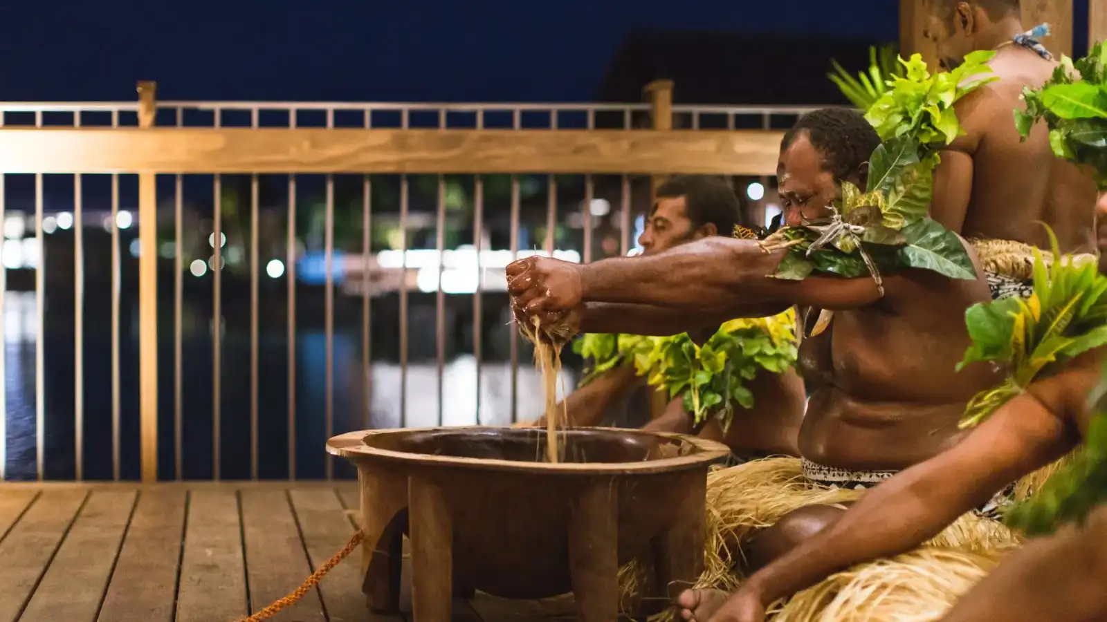 Traditional Fijian kava yaqona ceremony with participants seated cross-legged around wooden tanoa bowl demonstrating cultural respect and community bonding