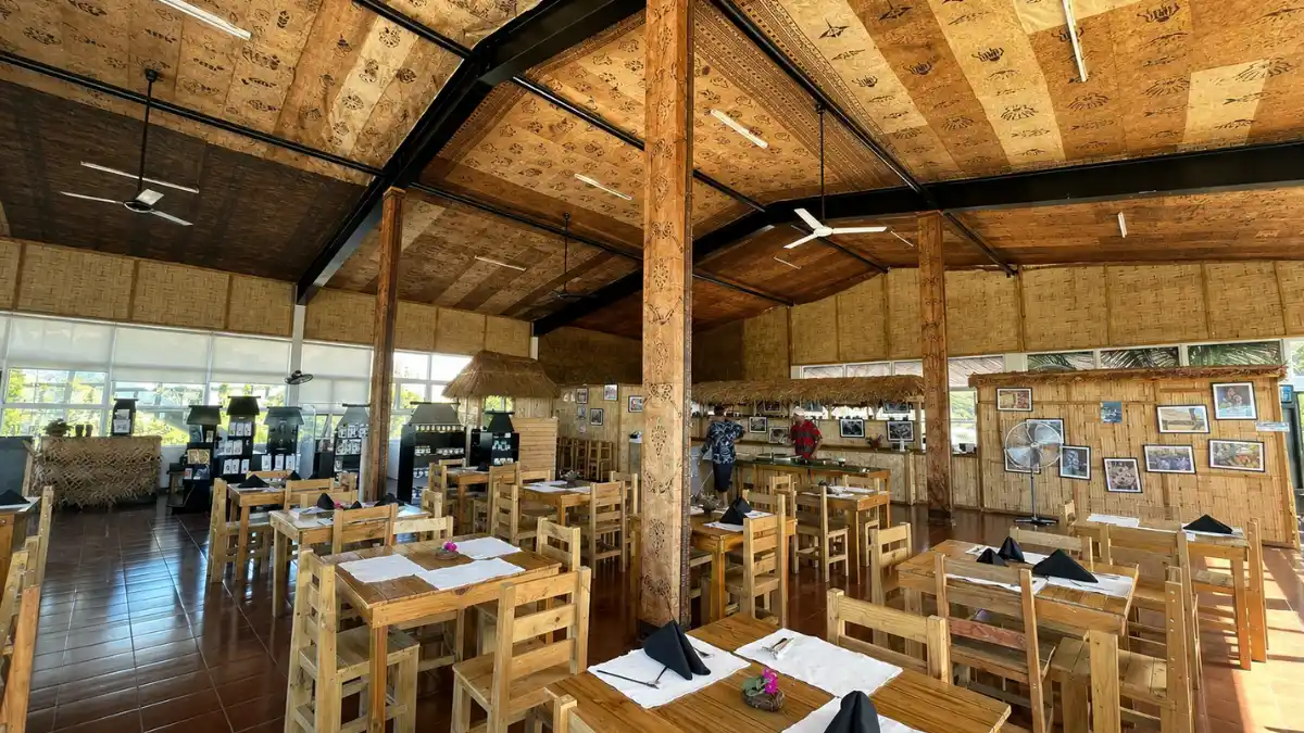 Dining room at Tukuni Restaurant in Tuvu, Lautoka, with wooden tables and woven wall panels.
