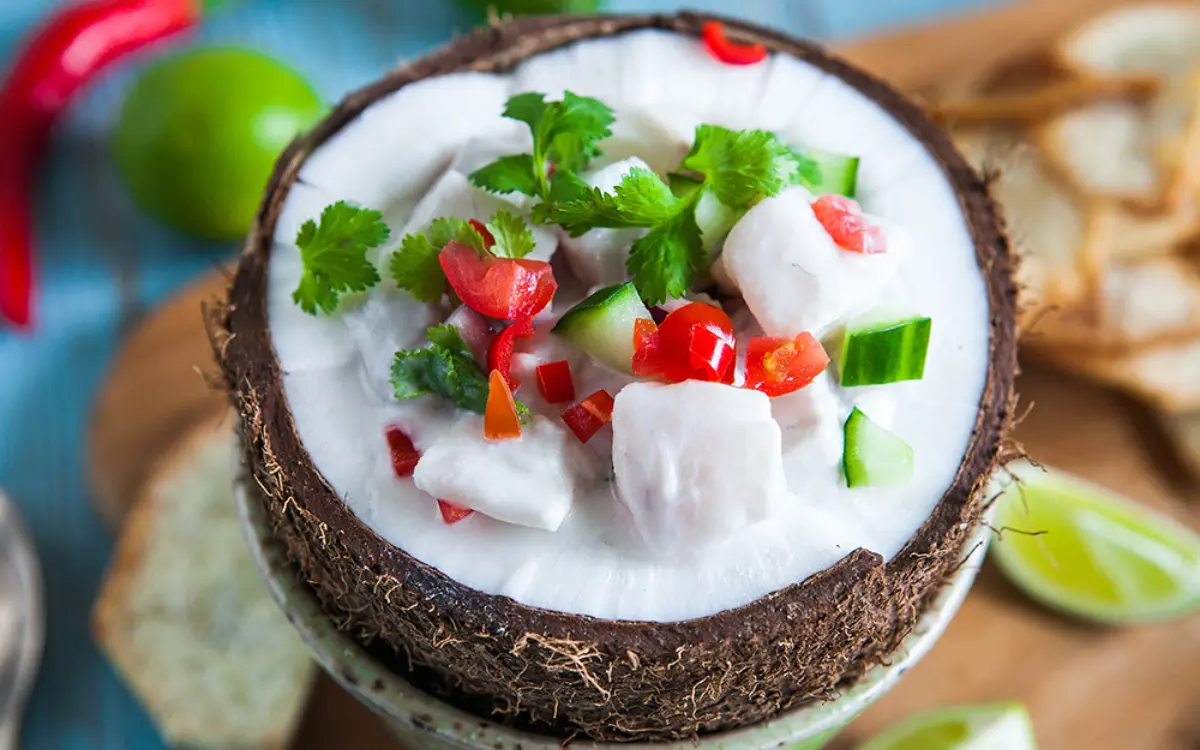Traditional Fijian kokoda served in a coconut shell with fresh fish, coconut cream, and tropical garnishes in Savusavu