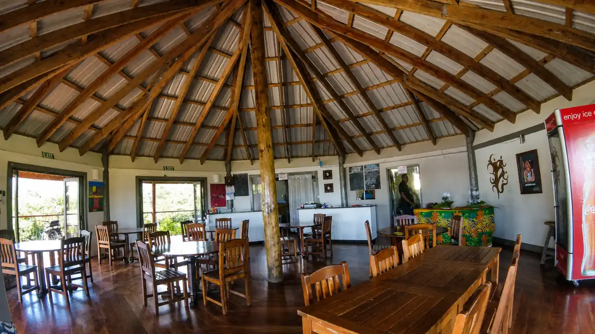 Simple dining room at The Junction Cafe and Restaurant in Cuvu, with wooden tables and a high timber roof