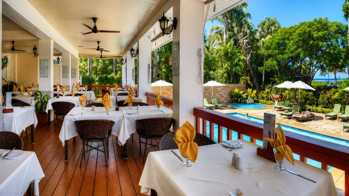 Covered dining veranda at Ocean Terrace Restaurant overlooking the pool and tropical gardens at Bedarra Beach Inn
