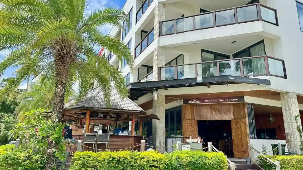 Exterior of Sitar Indian & Thai Restaurant at Korotogo Roundabout, with its open-air bar, entrance and palm garden