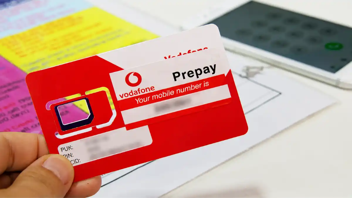 A Vodafone Fiji prepaid SIM card held beside a smartphone