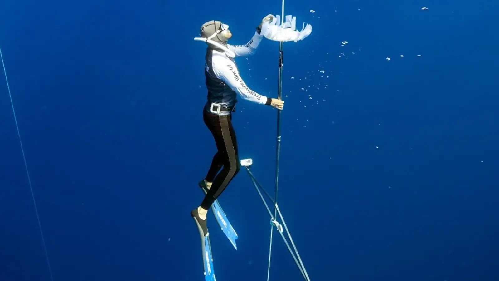 Freediver wearing a mask and long fins in open blue water