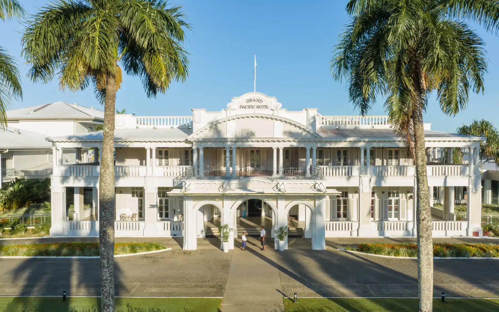The iconic white colonial exterior of the Grand Pacific Hotel in Suva, Fiji, with views of the harbor.