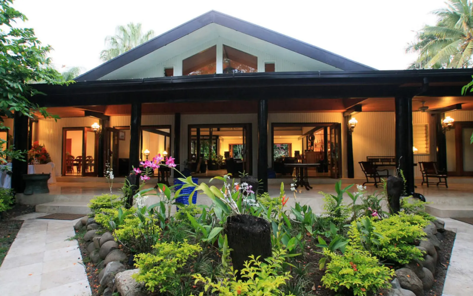 The elegant exterior view of The Fiji Orchid boutique resort, surrounded by lush tropical gardens and palm groves near Nadi.