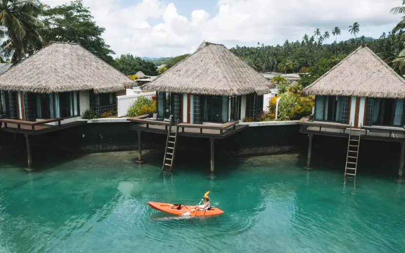 Overwater villas at Koro Sun Resort surrounded by tropical lagoon and rainforest