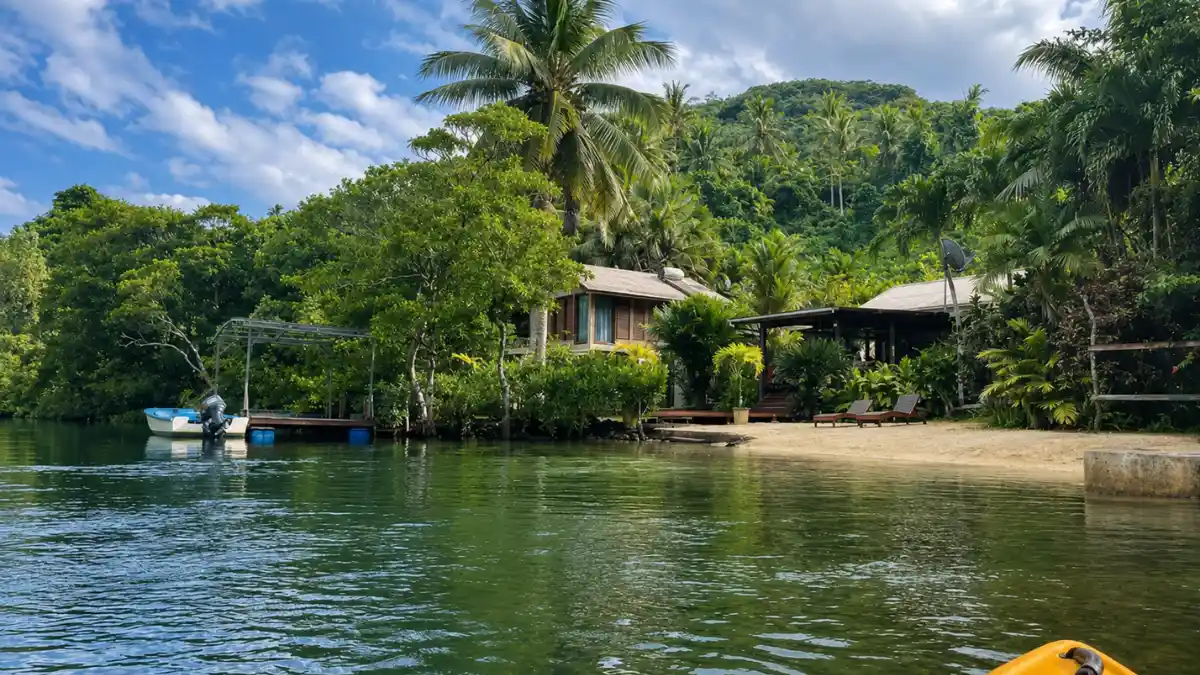 A bungalow and tropical gardens beside the tidal river at Salt Lake Lodge near Savusavu