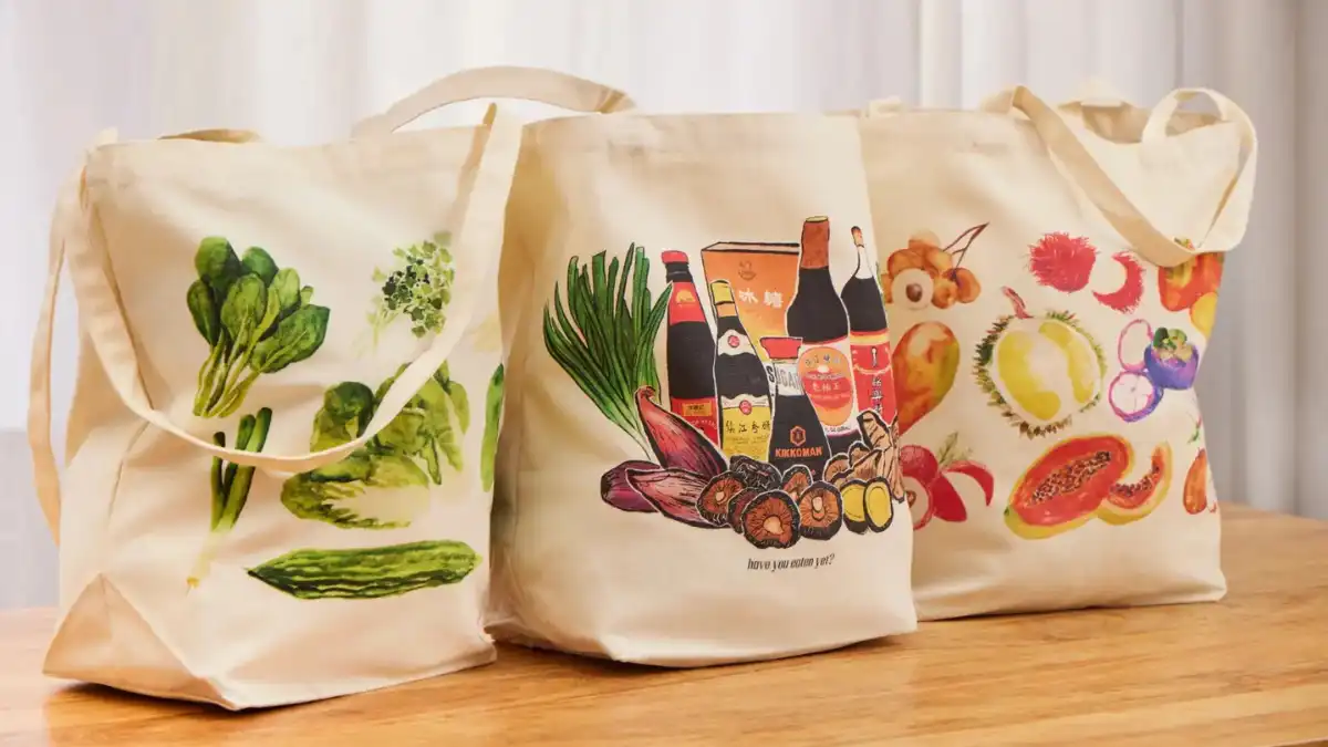 A reusable water bottle, cloth tote and lidded food container packed for a day trip from Nadi