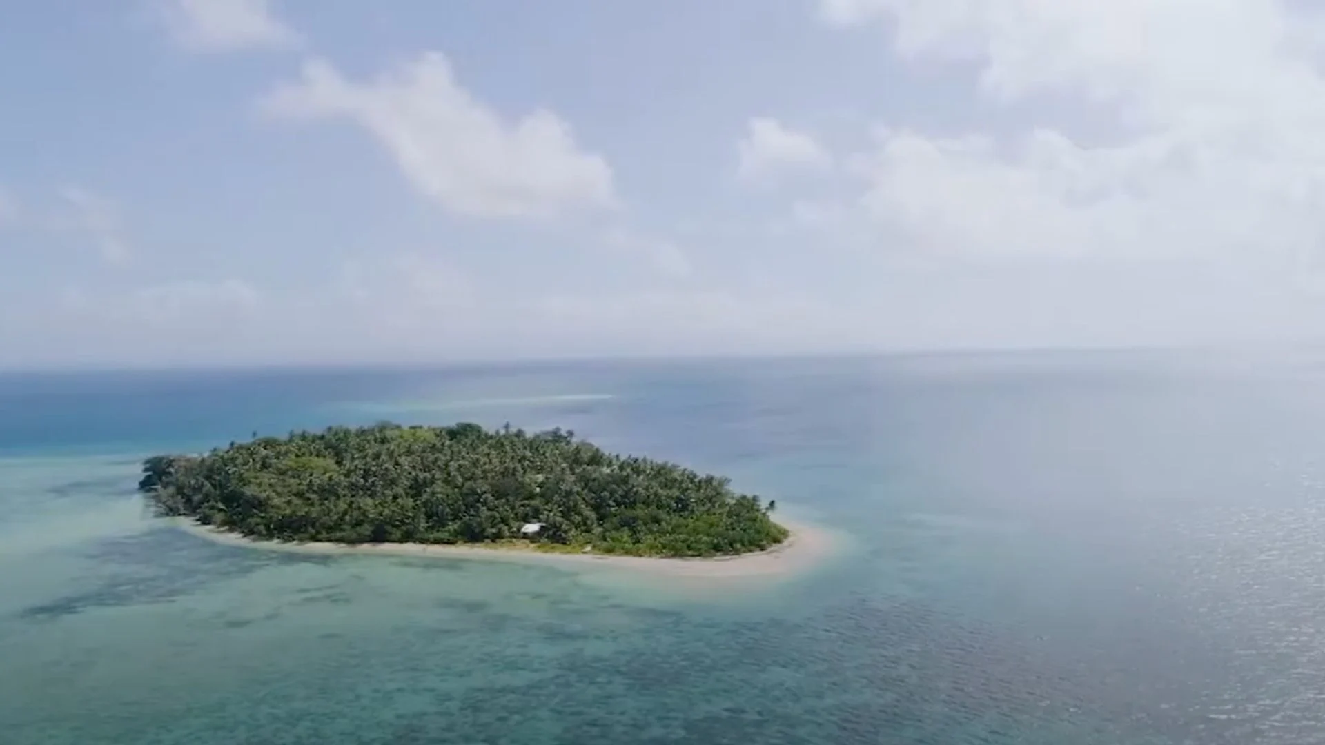 Aerial view of Caqalai Island showing pristine coral atoll surrounded by turquoise waters