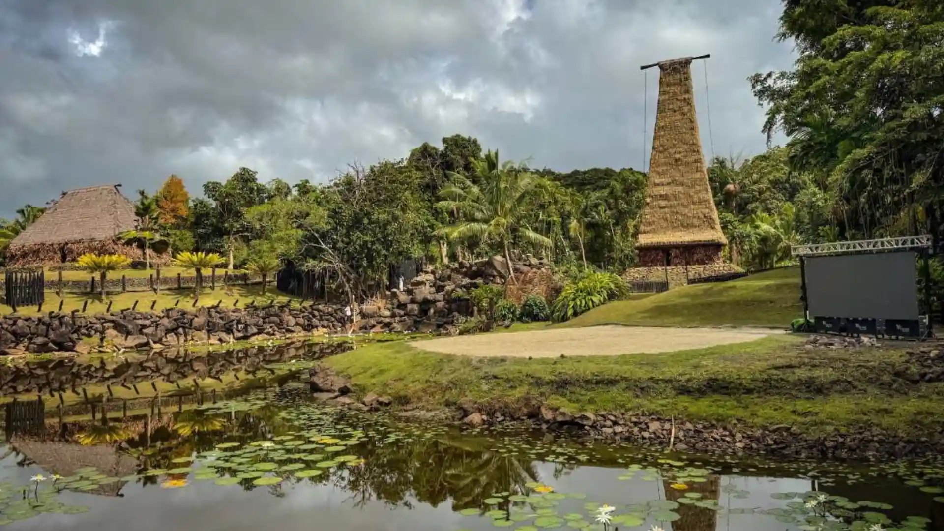 Traditional Fijian bure viewed from outside at Damodar Arts Village, surrounded by tropical vegetation and coastal serenity.